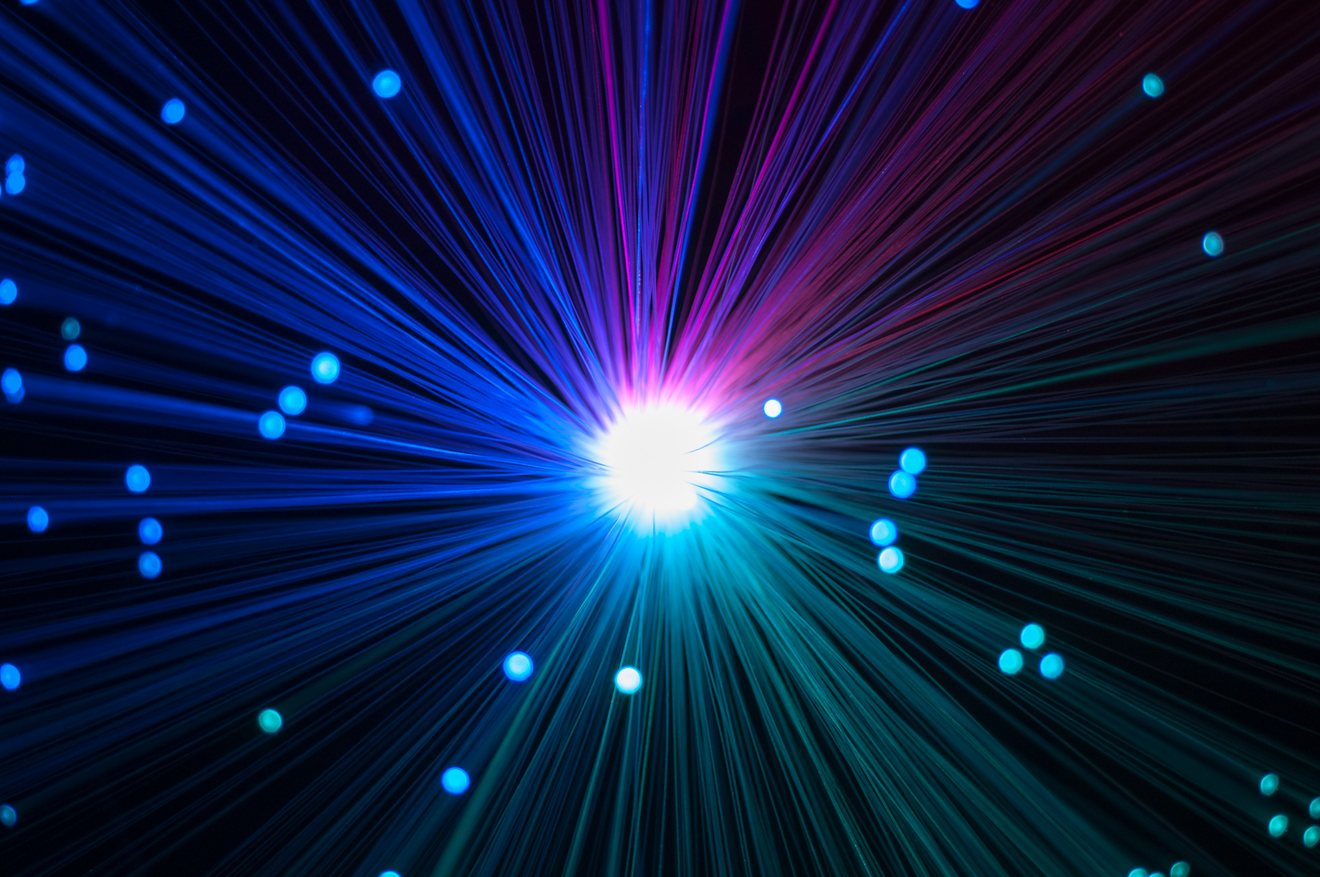 Bundled fibre optic strands radiating outward from a single white point of light